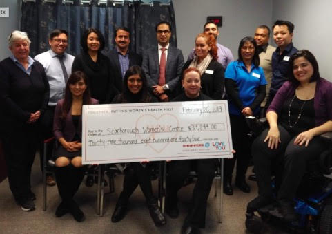 Group of Scarborough Women's Staff and Shoppers Drug Mart staff holding a donation cheque.